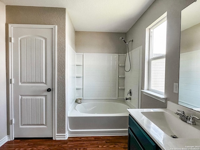 bathroom with vanity, plenty of natural light, wood-type flooring, and shower / bathing tub combination