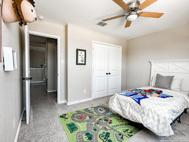 bedroom with a textured ceiling, a closet, ceiling fan, and carpet