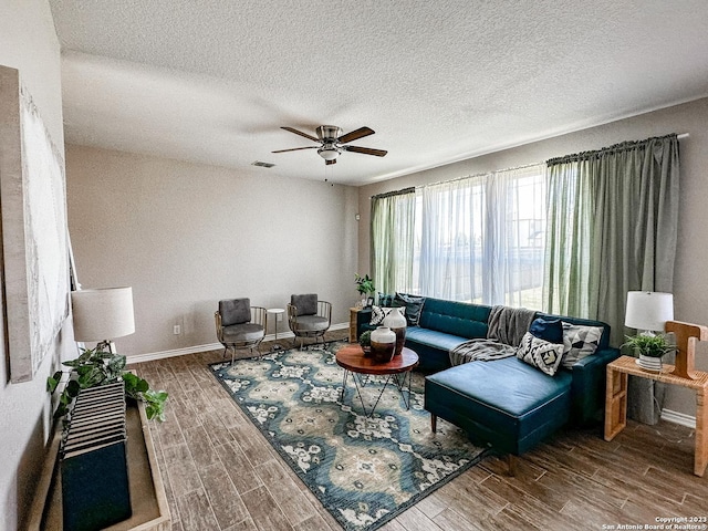 living room with ceiling fan and a textured ceiling