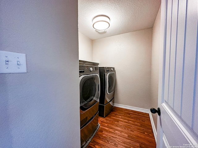 laundry area with separate washer and dryer, dark wood-type flooring, and a textured ceiling