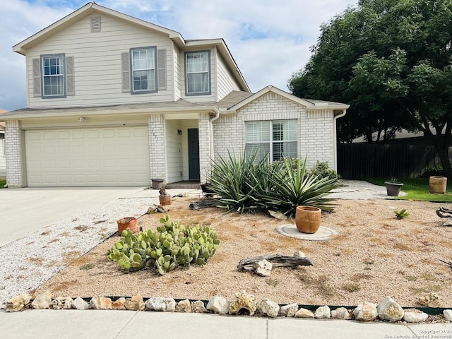 traditional-style house with concrete driveway, brick siding, fence, and an attached garage