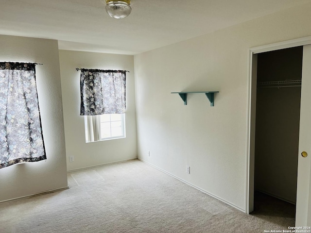 unfurnished bedroom featuring carpet, a closet, and a spacious closet