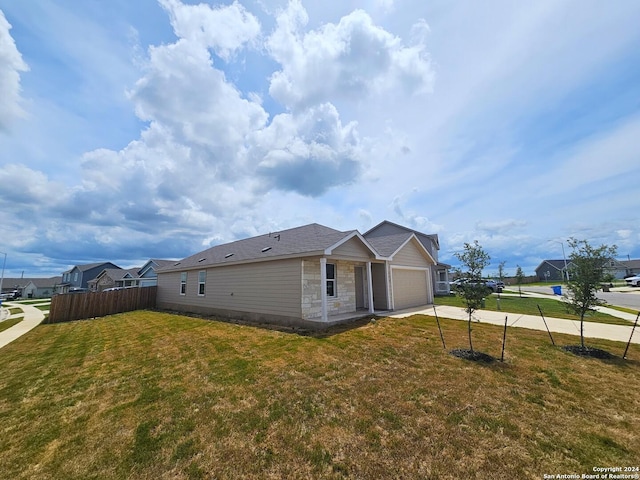 view of side of property featuring a lawn and a garage