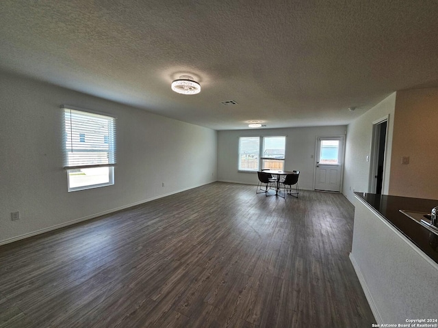 interior space featuring a textured ceiling and dark hardwood / wood-style floors