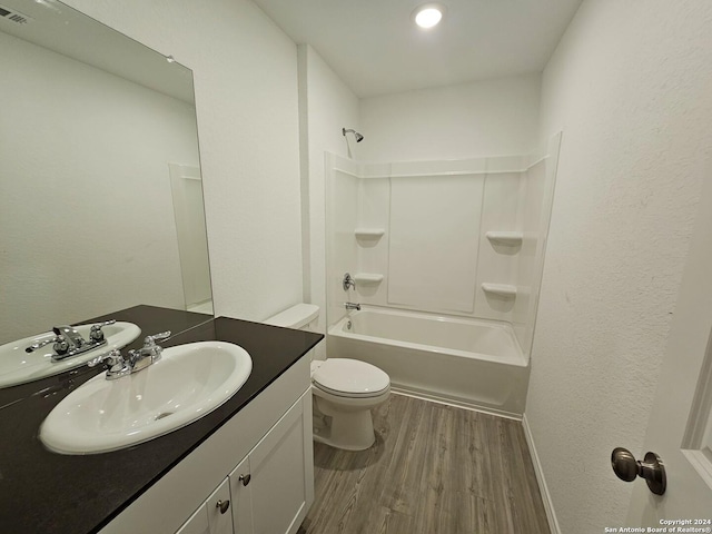 full bathroom featuring wood-type flooring, toilet, vanity, and shower / washtub combination