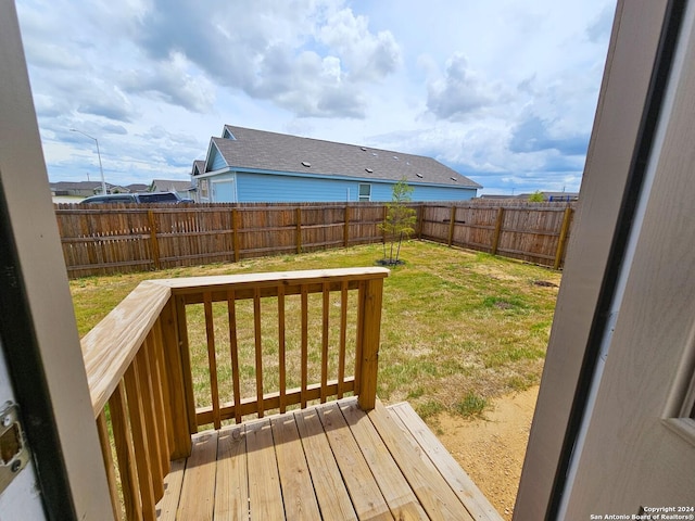 wooden terrace featuring a yard