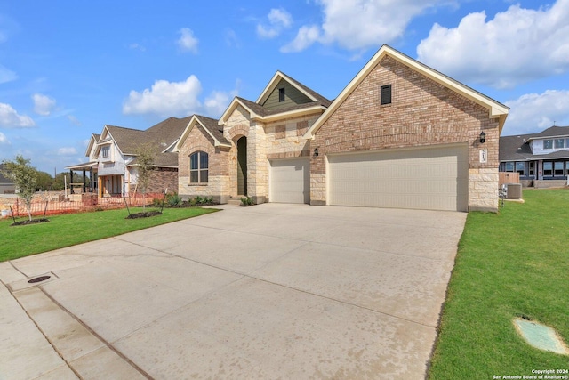 view of front of home featuring central AC unit, a garage, and a front lawn