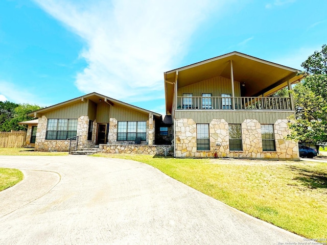 view of front of home with a balcony and a front lawn