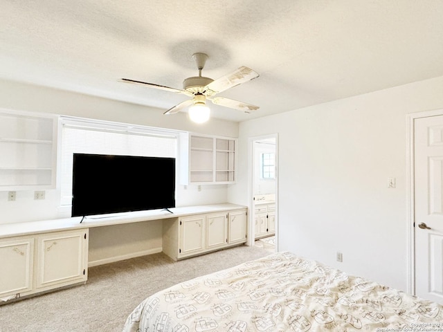 carpeted bedroom with built in desk and ceiling fan