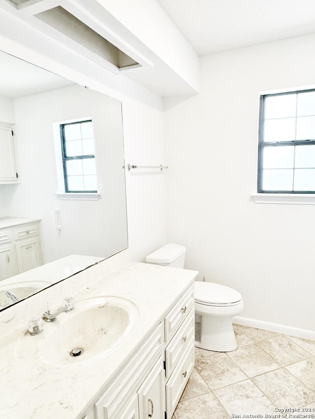 bathroom featuring tile patterned flooring, vanity, and toilet