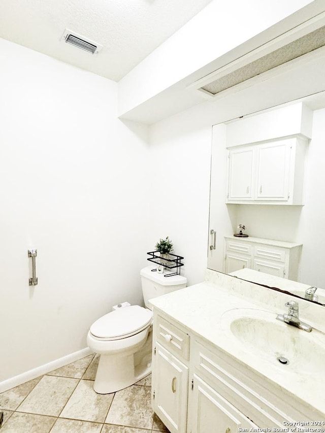 bathroom featuring toilet, vanity, tile patterned floors, and a textured ceiling