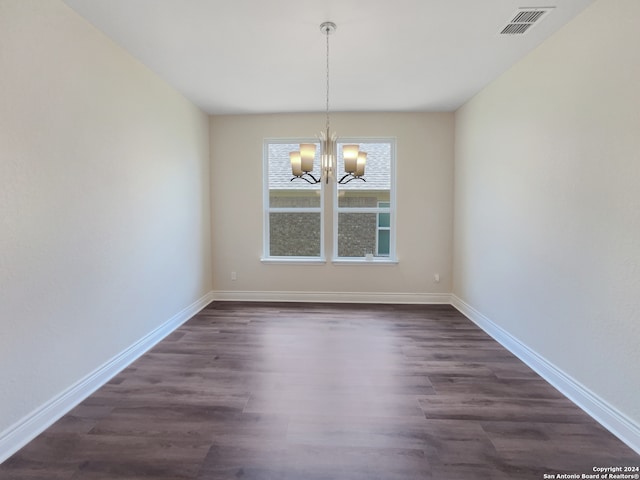 unfurnished dining area with dark hardwood / wood-style flooring and a notable chandelier