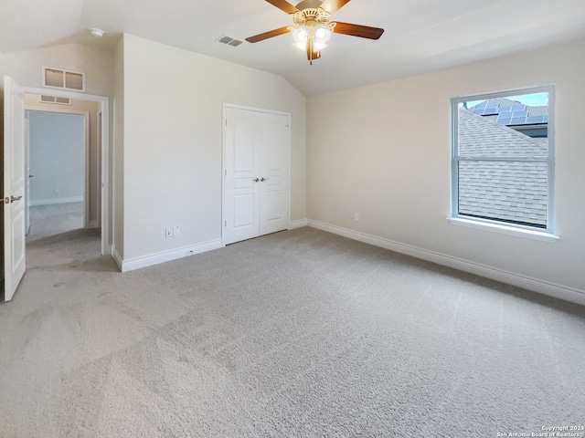 unfurnished bedroom featuring a closet, carpet flooring, ceiling fan, and vaulted ceiling