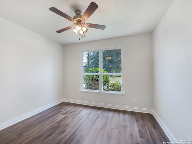 empty room featuring dark wood-type flooring and ceiling fan