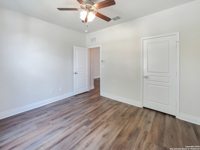 unfurnished room with dark wood-type flooring and ceiling fan