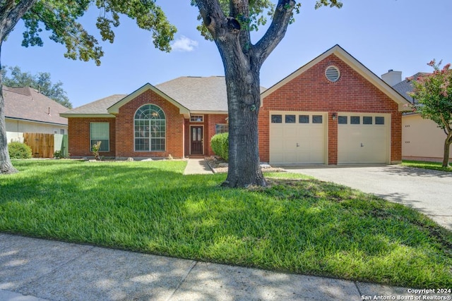 ranch-style house with brick siding, fence, a front yard, concrete driveway, and an attached garage