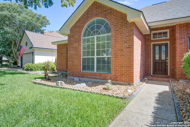 view of home's exterior with a lawn, a shingled roof, and brick siding