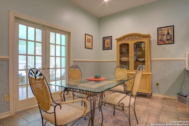 dining room featuring a wainscoted wall and french doors