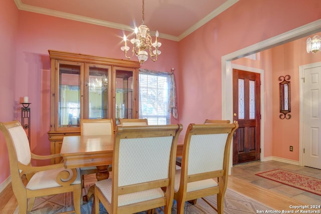 dining room with ornamental molding, a notable chandelier, wood finished floors, and baseboards