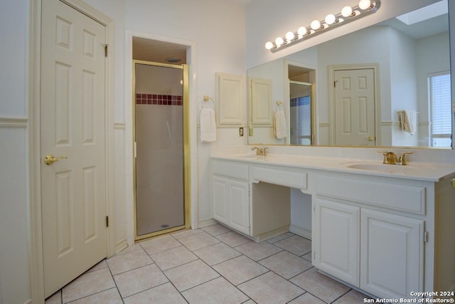 bathroom featuring double vanity, a sink, a shower stall, and tile patterned floors