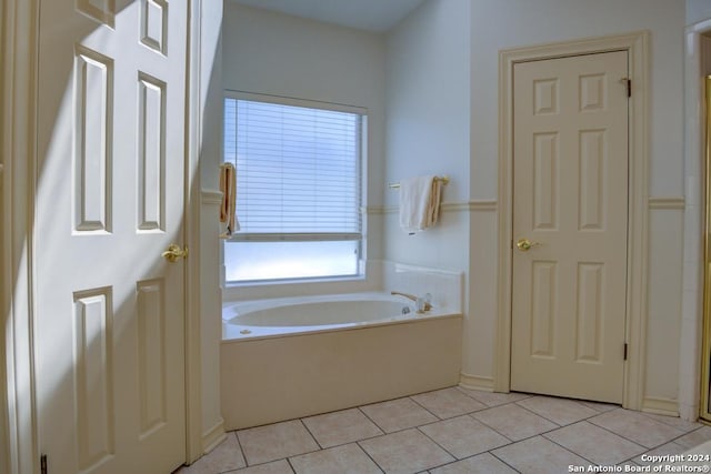 bathroom with tile patterned flooring and a bath