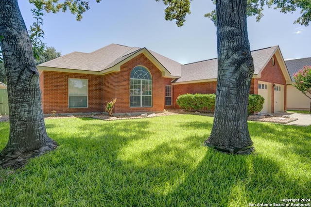 single story home with brick siding, a shingled roof, and a front yard