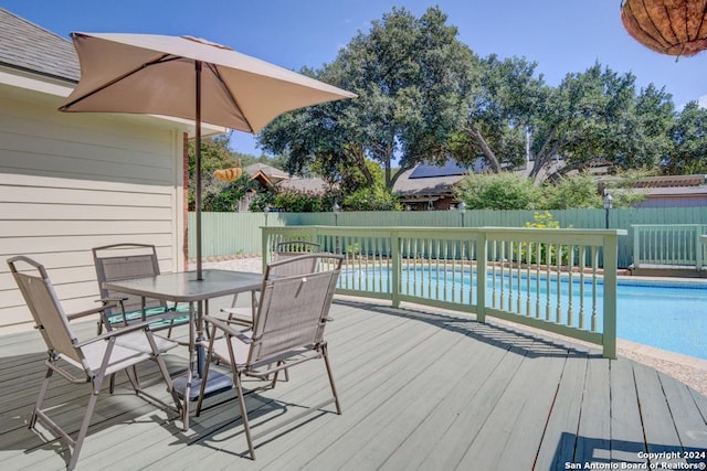 wooden terrace featuring a fenced in pool