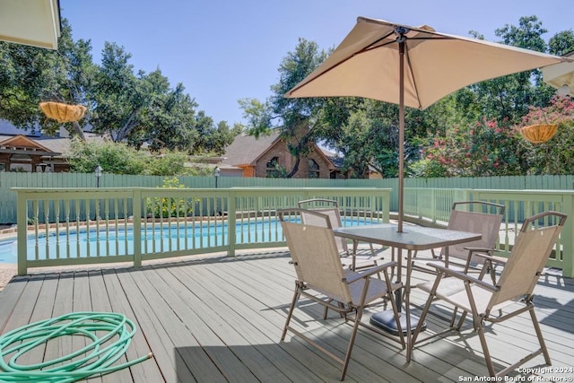 wooden terrace featuring a fenced backyard, outdoor dining area, and a fenced in pool