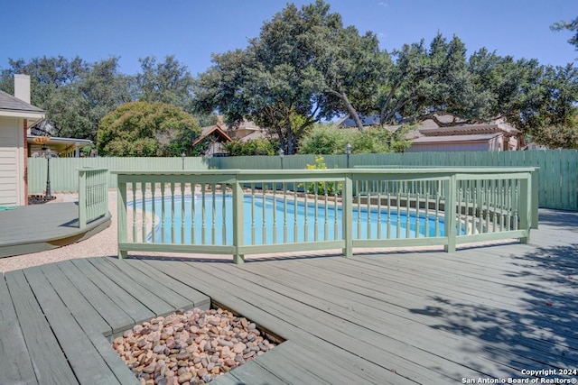 view of swimming pool with a deck, a fenced backyard, and a fenced in pool