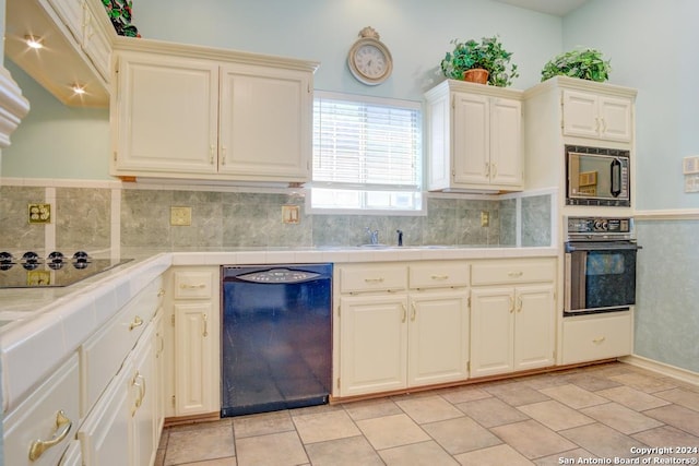 kitchen with light tile patterned floors, backsplash, black appliances, tile countertops, and sink