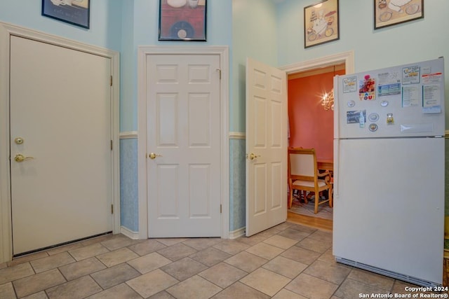 interior space with white refrigerator and light tile patterned floors