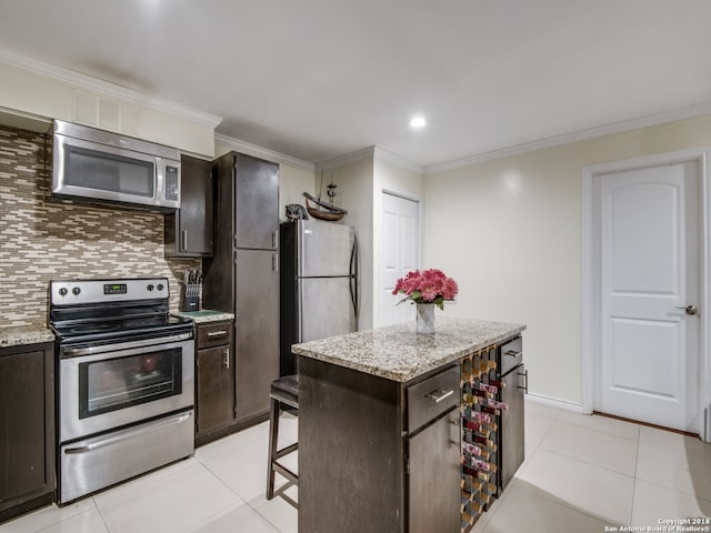 kitchen featuring backsplash, a center island, appliances with stainless steel finishes, and light tile patterned floors