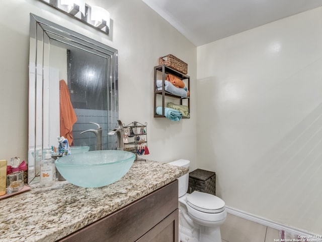 bathroom featuring vanity, tile patterned floors, and toilet