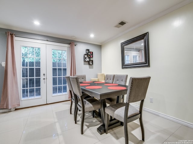 tiled dining room featuring crown molding and french doors