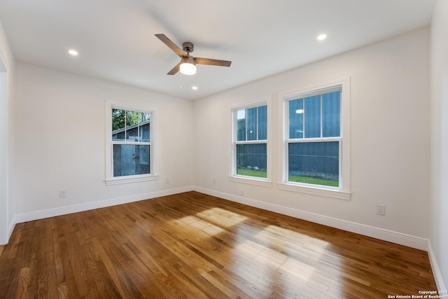 empty room with hardwood / wood-style floors and ceiling fan