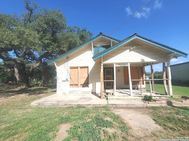 view of front of house featuring a patio and a front lawn