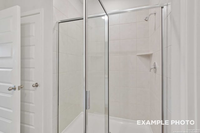 bathroom with a shower with door