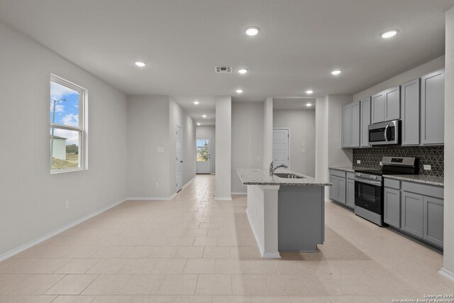 kitchen featuring stainless steel appliances, light hardwood / wood-style flooring, tasteful backsplash, and ceiling fan