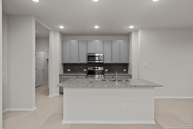 kitchen featuring appliances with stainless steel finishes, light hardwood / wood-style flooring, sink, decorative backsplash, and white cabinetry