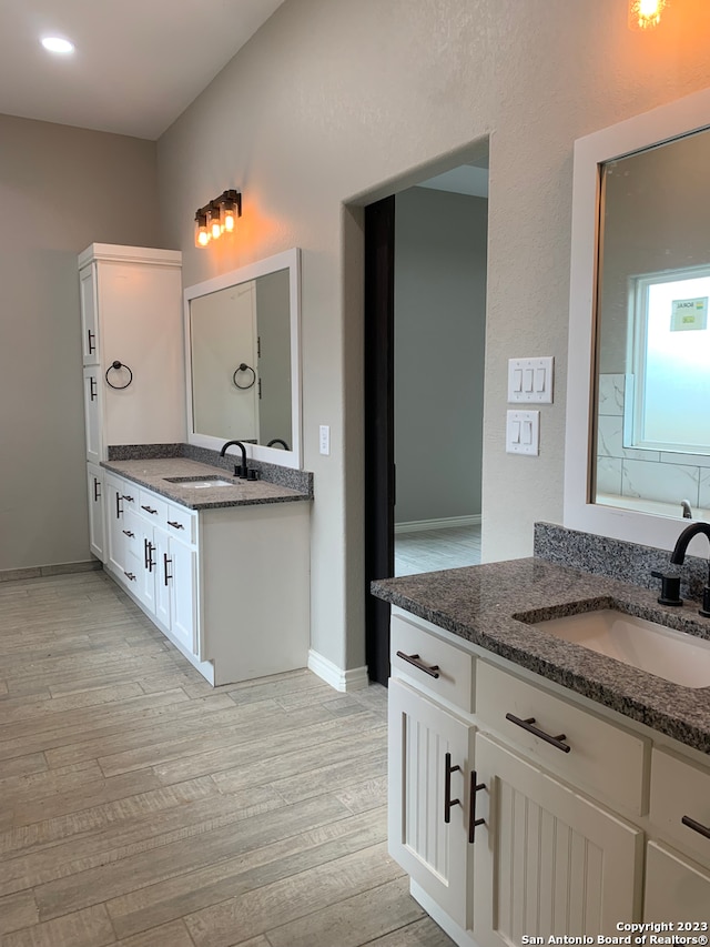 bathroom with wood-type flooring and double vanity