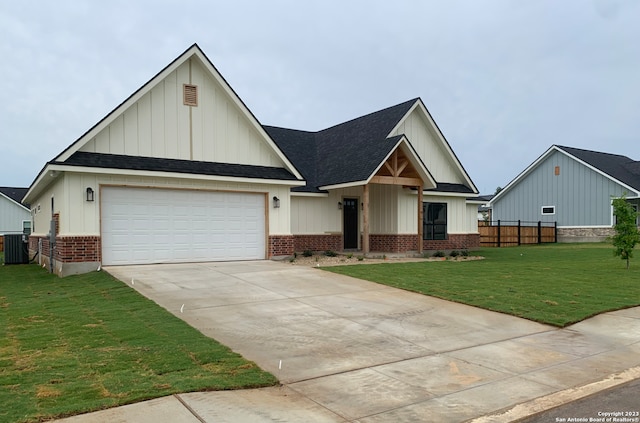 view of front of home with a garage, a front lawn, and central AC unit