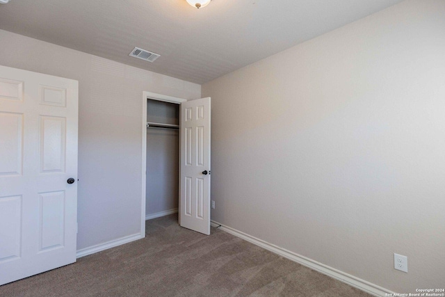 unfurnished bedroom featuring carpet floors and a closet