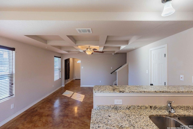 kitchen featuring beam ceiling, light stone countertops, sink, ceiling fan, and coffered ceiling