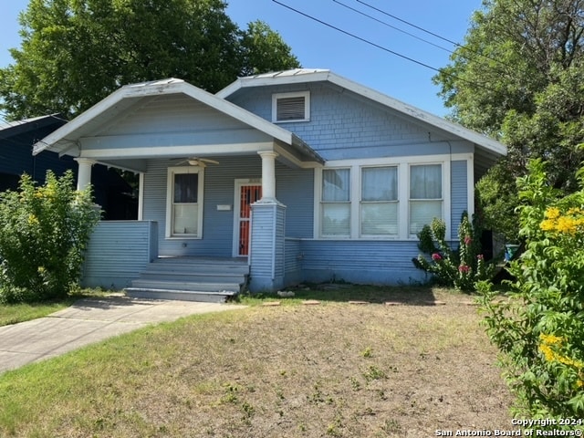 bungalow with covered porch and a front lawn