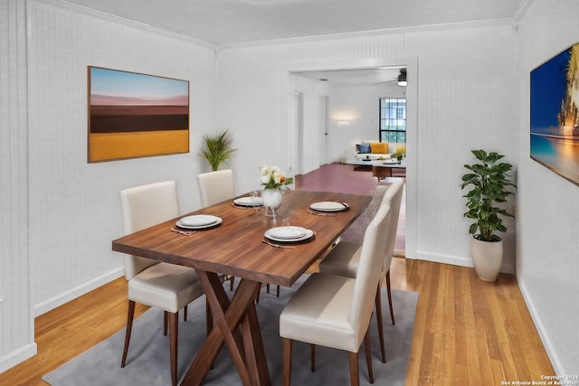 dining room featuring wood-type flooring, crown molding, and ceiling fan