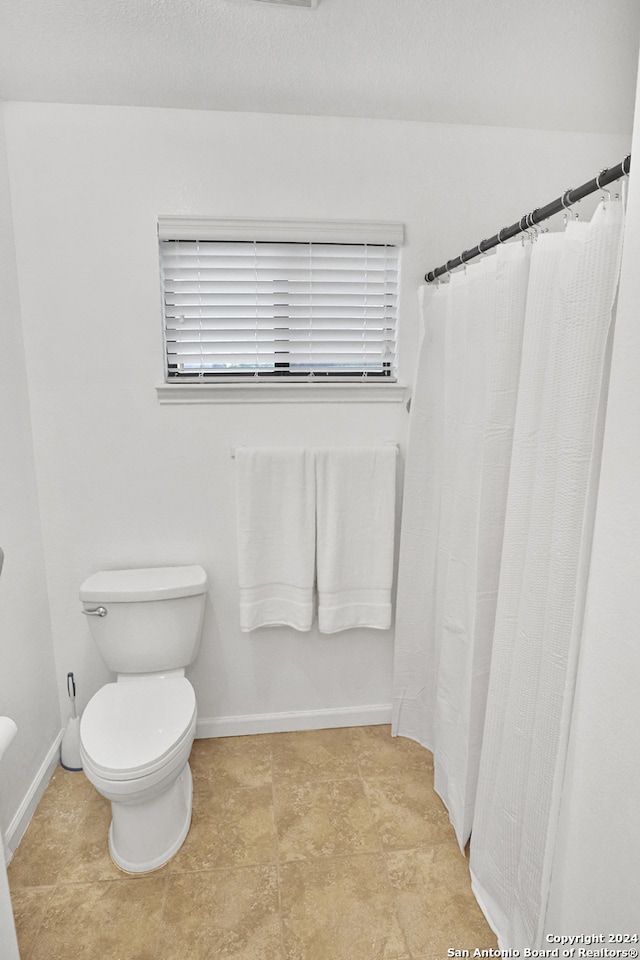 bathroom with toilet and tile patterned floors