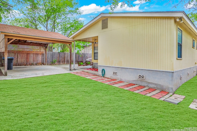 view of side of property featuring a patio and a lawn