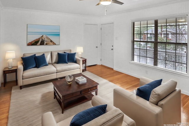 living room with wood-type flooring, crown molding, and ceiling fan