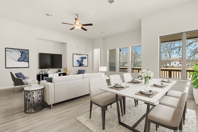 dining area with ceiling fan and light wood-type flooring