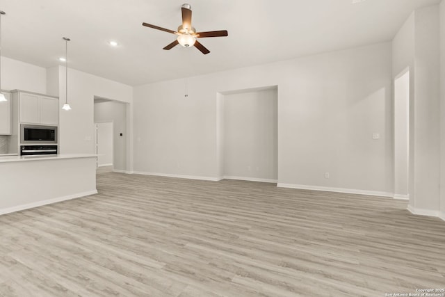 unfurnished living room with ceiling fan and light hardwood / wood-style floors